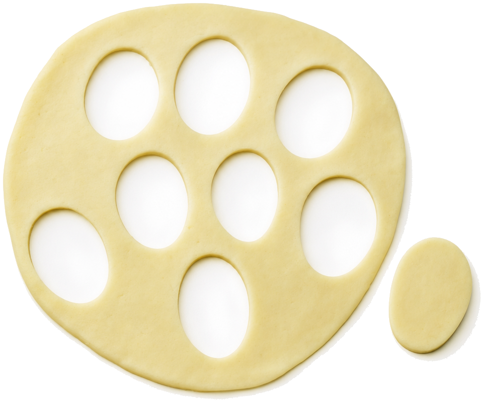 A pale dough sheet with oval cutouts